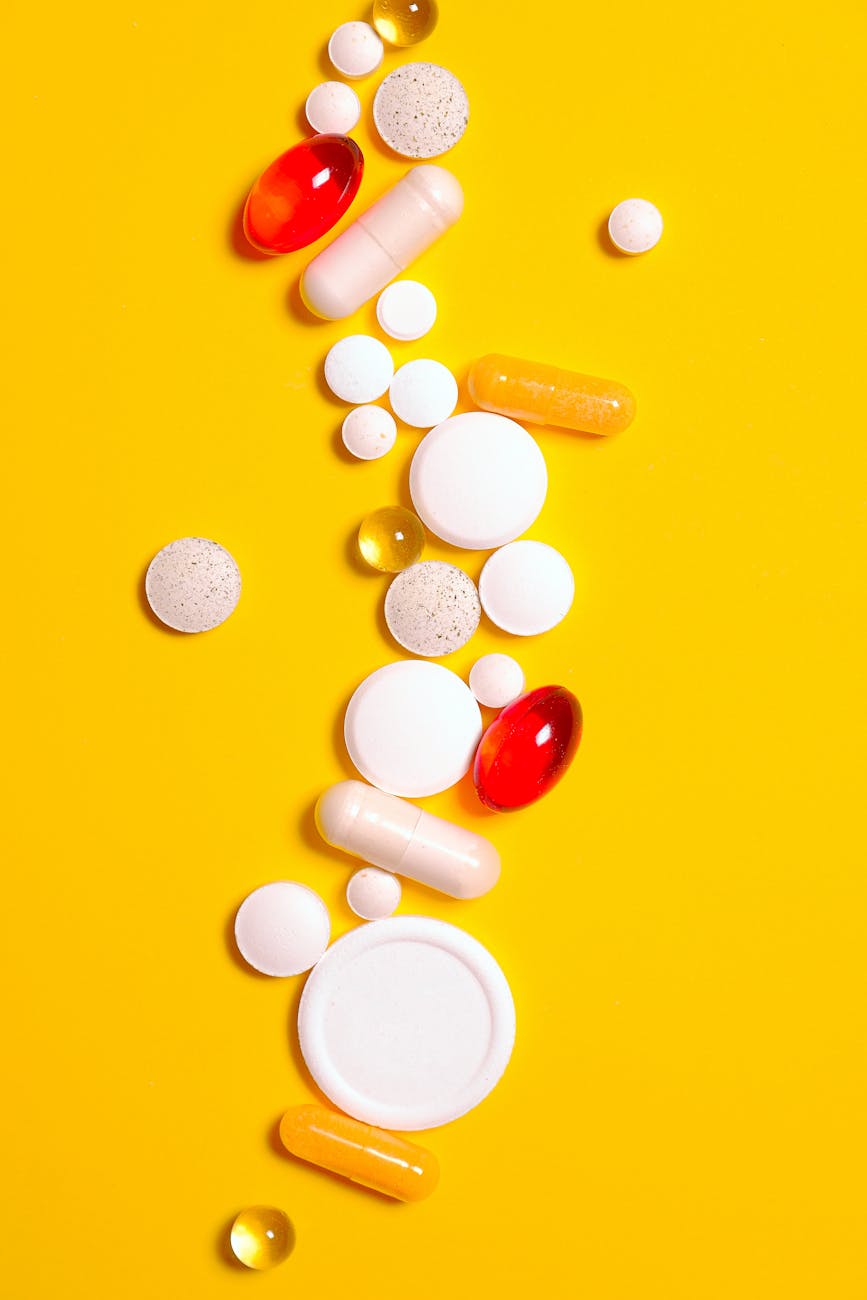 bunch of medicine pill on yellow textile